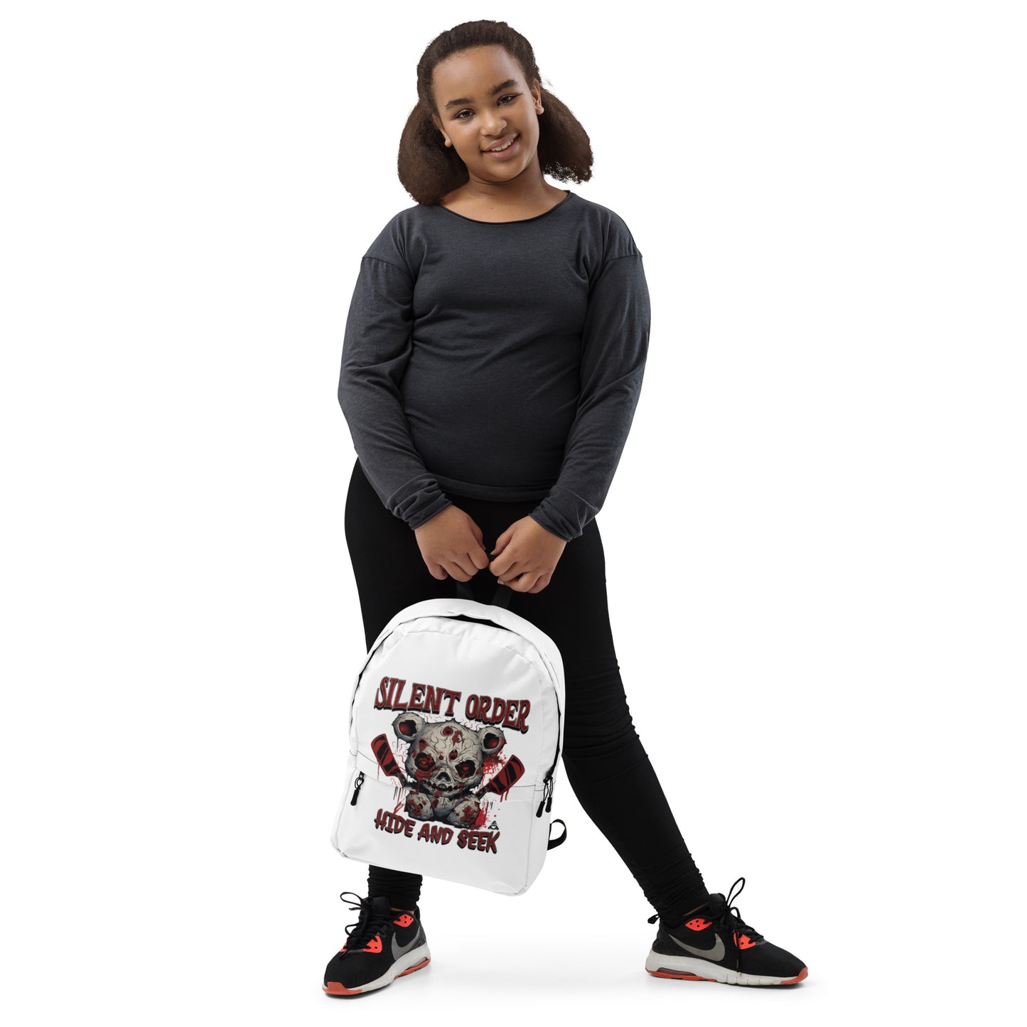 Person wearing a black outfit with a white backpack featuring a bear graphic and text.