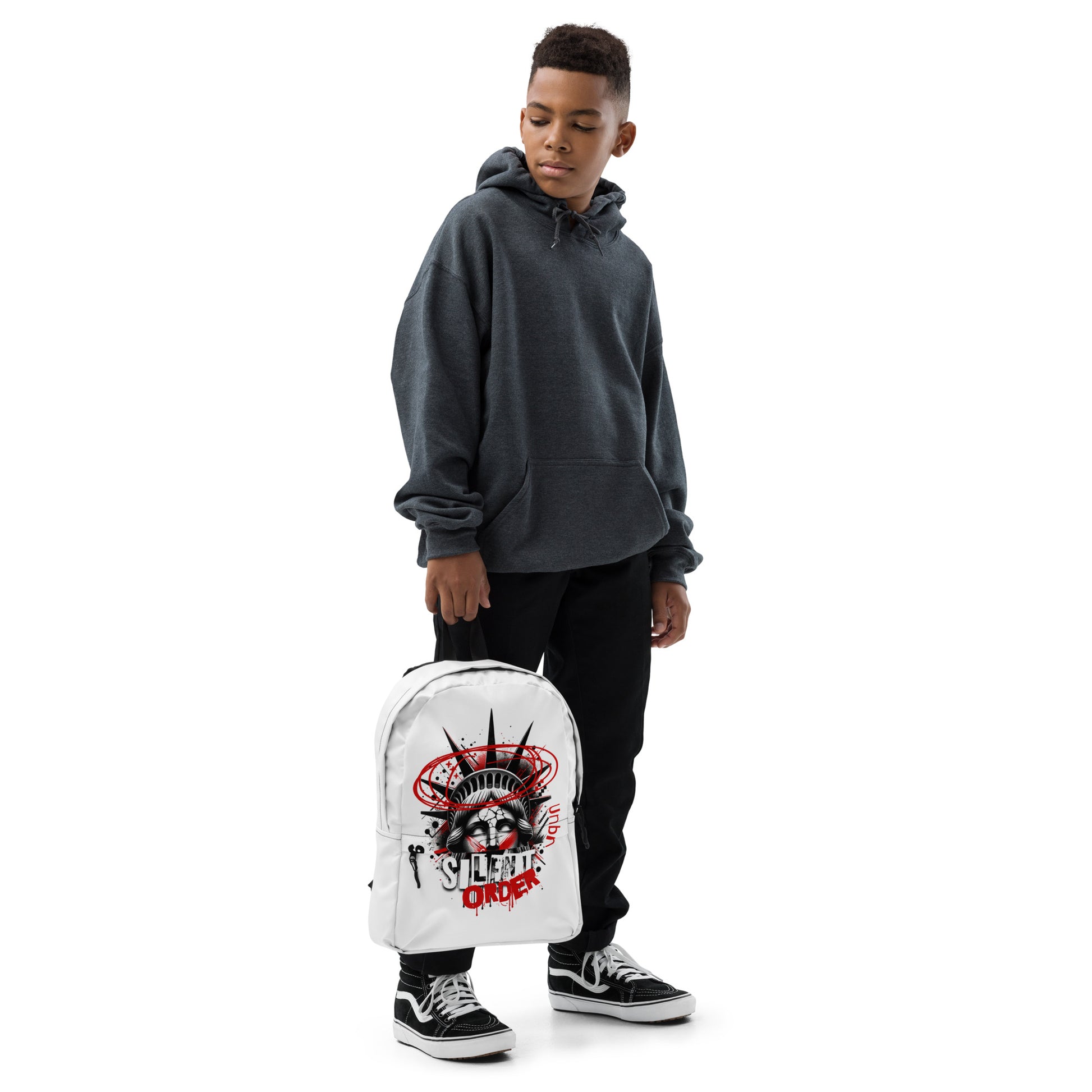 Person wearing a gray hoodie and black pants, holding a white backpack with a design on a white background