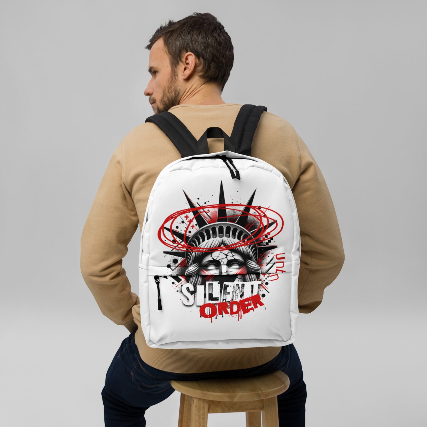 Man wearing a white backpack with graphic design on a gray background