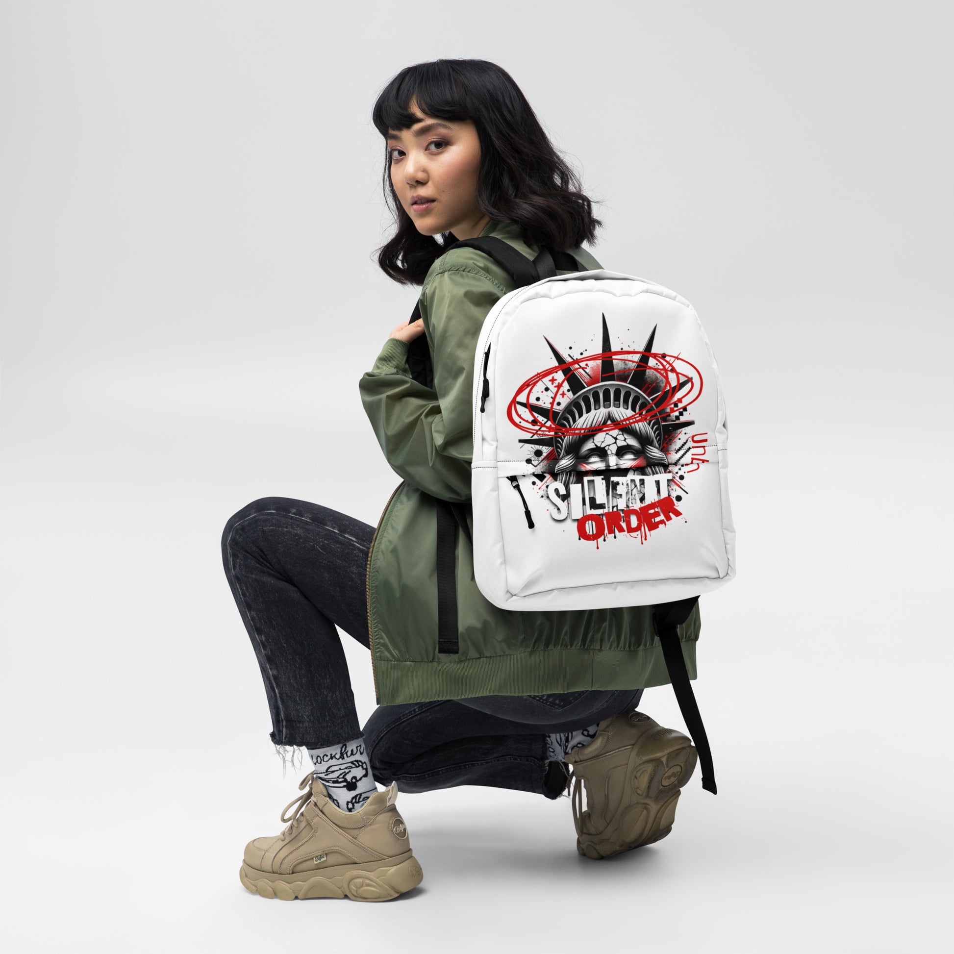 Person wearing a white backpack with a graphic design on a plain background