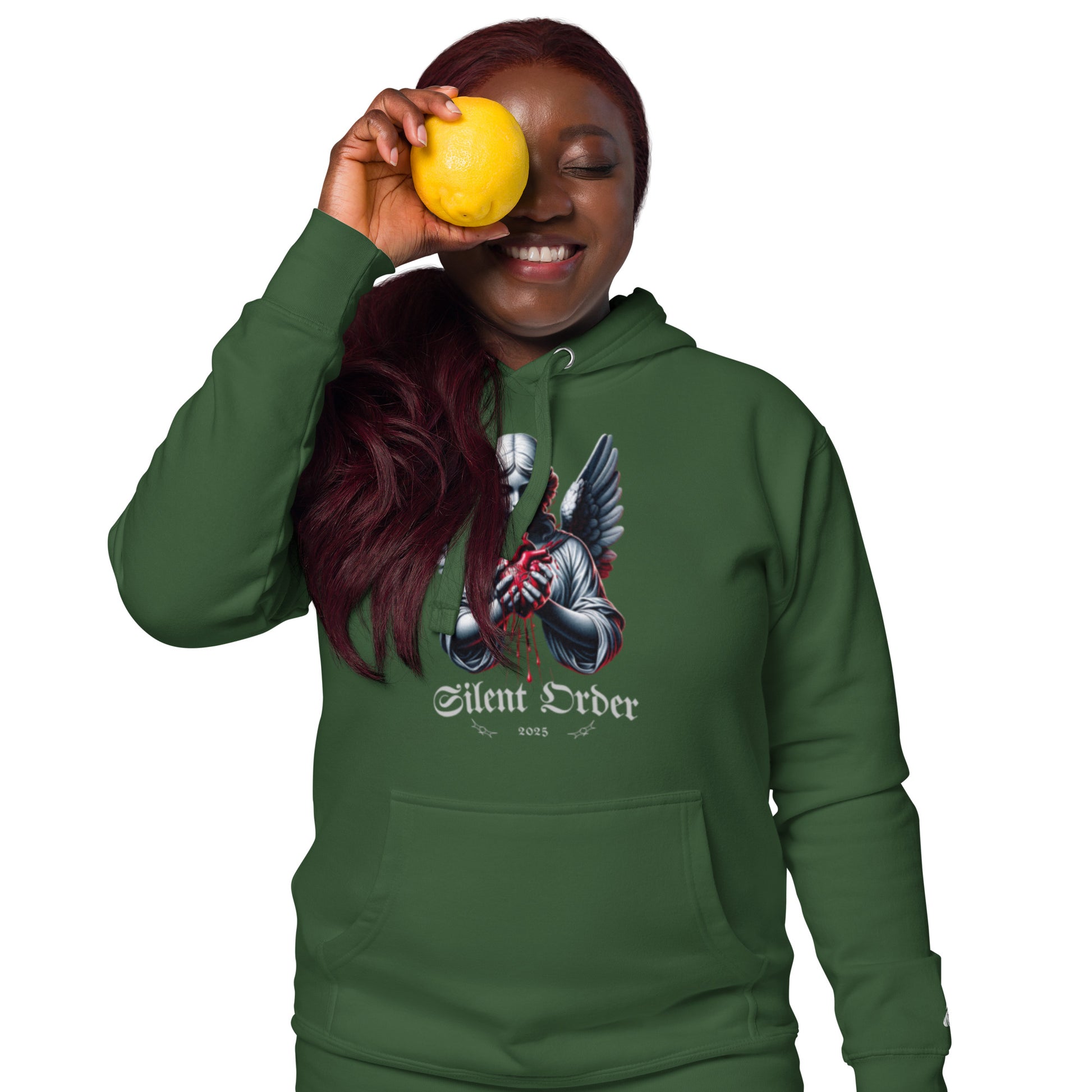 Person wearing a green hoodie with a graphic design, holding a yellow fruit.