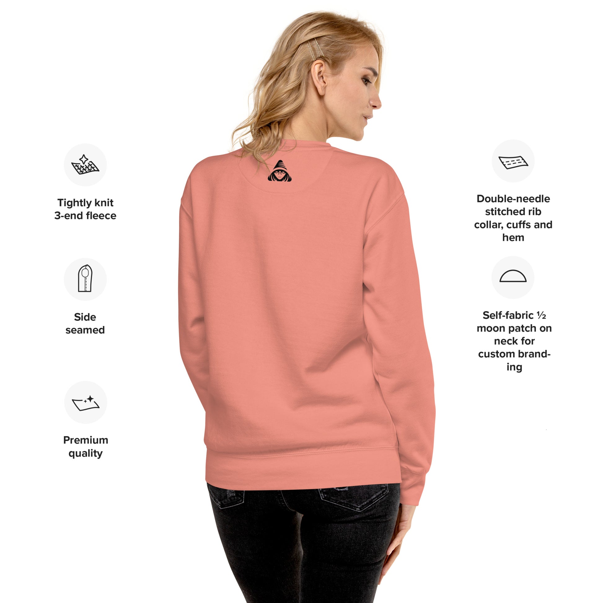 Person wearing a pink sweatshirt with text detailing garment features on a white background
